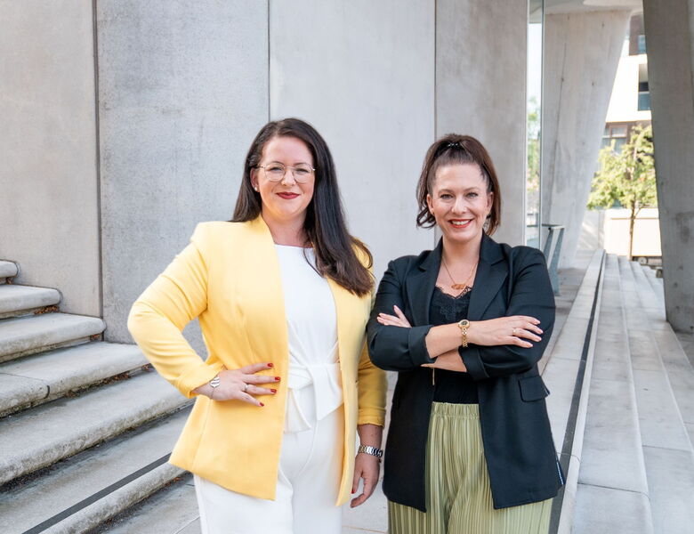 Zwei Personalberaterinnen von Grabowski & Rohmann Personalberatung Hamburg – eine trägt einen gelben Blazer, die andere einen schwarzen Blazer mit grünem Plisseerock – Expertinnen für IT-Personalberatung