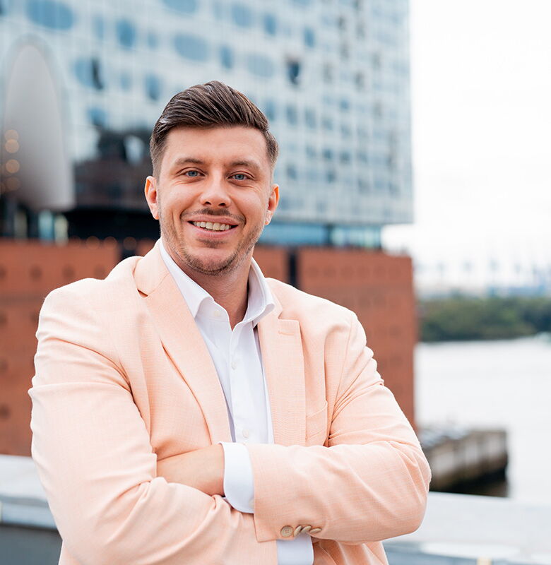 Mitarbeiter von Grabowski & Rohmann Personalberatung Hamburg im hellbeigen Sakko vor der Elbphilharmonie – moderner Personalberater und Experte für Recruiting und IT-Personalvermittlung